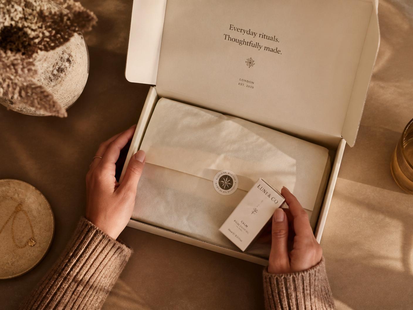 Hands unboxing a premium ecommerce delivery box